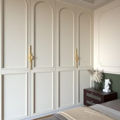 a bedroom with white closets and a bed in front of the door to another room