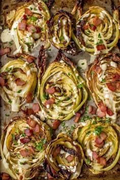 an overhead view of some artichokes on a baking sheet with bacon and cheese