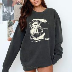 Surfer Ghoul Sweatshirt - Ride the Waves of Style This Halloween and Beyond! 🌊 Are you ready to catch some serious style this season? Dive into the spirit of Halloween with our Surfer Ghoul Sweatshirt, where the laid-back vibes of surfing meet the playful spookiness of the season! This isn't just any sweatshirt; it's your new go-to piece that combines comfort, uniqueness, and a whole lot of character. 🧵 Product Features: Premium Fabric: Made from 80% ring-spun cotton and 20% polyester, our swe Grunge Long Sleeve Sweater With Graphic Print, Casual Halloween Sweater With Crew Neck, Casual Halloween Crew Neck Sweater, Casual Crew Neck Halloween Sweater, Casual Crew Neck Sweater For Halloween, Oversized Band Merch Long Sleeve Sweatshirt, Casual Sweatshirt With Screen Print, Grunge Long Sleeve Sweatshirt With Letter Print, Oversized Long Sleeve Band Merch Sweatshirt