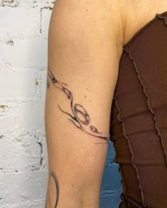 a woman's arm with a tattoo on it that has scissors in the middle