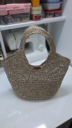 a purse sitting on top of a white counter next to a shelf filled with craft supplies