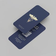 two blue business cards sitting side by side on top of each other, one with a gold cadus logo