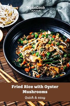 fried rice with oyster mushrooms and vegetables in a black bowl next to chopsticks