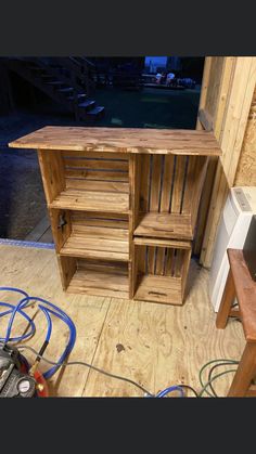 a wooden cabinet sitting on top of a hard wood floor next to a power source