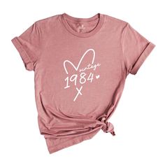 a women's pink shirt with white writing on it