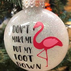 a glass ornament with a pink flamingo on it that says, don't make me put my foot down