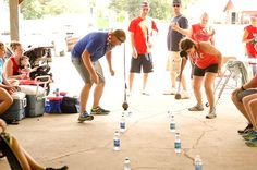 a group of people standing around each other with bottles on the ground in front of them