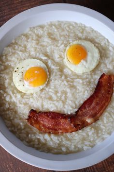 rice with bacon and eggs in the shape of a smiley face on top of it