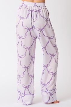 Light purple satin pajama pants with dark purple bow tie print You'll have the Sweetest Dreams in these purple satin pajama pants! Featuring a light purple satin fabric with dark purple bow tie print, an elastic waistband, front pockets, and wide legs with dark purple trimmed cuffs. Perfect for bedtime, or comfy lounging. Grab the matching top and get ready to trend while your sleep! Fits true to size; relaxed silhouette Fabric contains stretch Model is wearing a small Elastic waistband Front po Purple Sleepwear For Pajama Party In Spring, Purple Sleepwear For Spring Pajama Party, Purple Bottoms For Pajama Party In Spring, Purple Bottoms For Spring Pajama Party, Purple Bottoms For Pajama Party In Summer, Purple Bottoms For Summer Pajama Party, Purple Pants For Pajama Party, Trendy Purple Bottoms For Loungewear, Trendy Purple Loungewear Bottoms