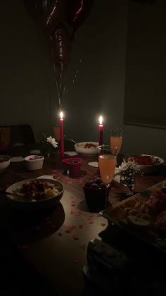 a table topped with plates of food and candles