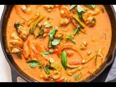 a pan filled with chicken and vegetables on top of a table