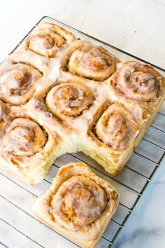 cinnamon rolls are cooling on a wire rack