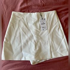 This Zara Skort (Skirt With Shorts) Is New With Tags And Comes In A Beautiful Shade Of White. It Is A Very Versatile Piece, As It Can Be Used In Hotter Weather Or Paired With A Sweater During The Upcoming Fall/Winter Months. It Is Marked A Size Large And Has A Zip Closure. Elegant Zara Bottoms With Lined Skirt, Elegant Lined Skirt From Zara, Elegant Zara Lined Skirt, Skirt Bottoms With Built-in Shorts For Day Out, Day Out Skirt With Built-in Shorts, Skirt With Built-in Shorts For Day Out, Elegant Skirt-style Shorts For Spring, Elegant Short Skirt For Day Out, Zara Pleated Skirt Bottoms For Spring