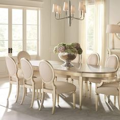 a dining room table with chairs and a vase filled with flowers