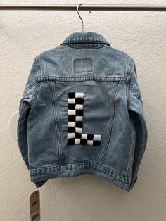 Handmade personalized embroidered jean jacket.  Each jean jacket has the chosen letter with hand stitched checkered print. any color combo from my selected colors can be chosen. Please message me your color choices.  **Please make sure to read the personalization section and send all information.**  Delay in personalization information will delay the creation time of your jean jacket.  Because of the personalized nature of this product, refunds and exchanges are not accepted. If you have an issue with your order, please reach out to me directly. **Hand wash only, lay flat to dry** Customizable Fitted Denim Jacket Casual Style, Trendy Cotton Outerwear With Letter Embroidery, Casual Fitted Denim Jacket Customizable, Customizable Fitted Cotton Outerwear, Trendy Customizable Outerwear For Spring, Customizable Cotton Denim Jacket For Fall, Customizable Cotton Fall Outerwear, Casual Customizable Blue Outerwear, Long Sleeve Denim Jacket With Custom Embroidery For Fall