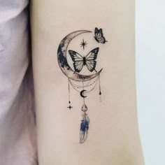 a woman's arm with a butterfly and moon tattoo on the left side of her arm