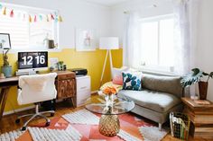 a living room filled with furniture and a computer on top of a desk in front of a window