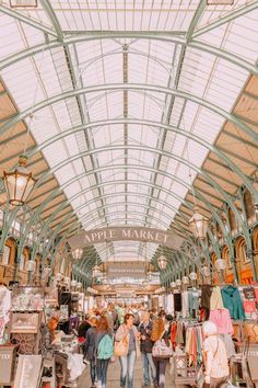 people are walking through an indoor market with lots of goods on display in the aisles