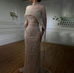 Made to order dresses will ship in 2-3 weeks as they are custom created. Unleash your inner goddess in our Luxurious Beaded Cape Dress! Featuring a champagne beaded bodice and a removable cape, this dress exudes opulence and elegance. Cinch your waist with the included satin lined belt for a flattering silhouette. Perfect for any special occasion, this dress drips with luxury. SIZE & FIT Model wears: UK 8/ EU 36/ US 4 Model's height: 171cm/5'7.5” LOOK AFTER ME Dry clean only Made to order dresse