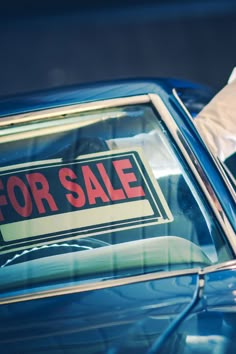 a blue car with a for sale sign on it