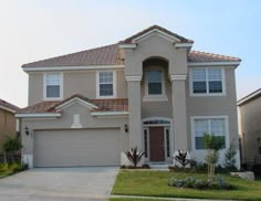 a two story house with brown roof and white trim