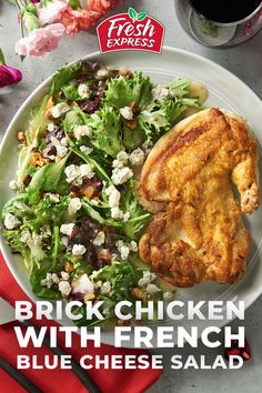 a white plate topped with chicken next to a salad