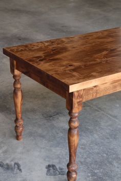 a wooden table sitting on top of a cement floor