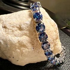 a blue bracelet sitting on top of a rock