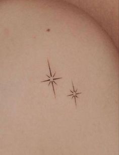 two small stars on the back of a woman's shoulder