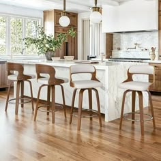 a kitchen with wooden cabinets and white counter tops, along with bar stools that match the hardwood flooring