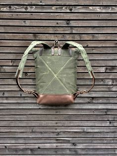 "Backpack made from heavy weight waxed filter twill in the color olive green with an outside pocket made in oiled leather.(color of the leather is dark taupe) I made it into an everyday backpack/rucksack, with waxed filter twill padded straps. Roll to close top, and outside pocket with protective flap, bottom and roll to close piece made in oiled leather. The bag closes with roll to close system and double snap closing This rucksack is fully lined with a cotton canvas fabric, and a padded backsi Khaki Waxed Canvas Backpack For Outdoor, Everyday Waxed Canvas Backpack With Leather Patch, Khaki Waxed Canvas Backpack, Khaki Waxed Canvas Standard Backpack, Waxed Canvas Backpack, Canvas Leather Bag, Everyday Backpack, Cotton Canvas Fabric, Dark Taupe