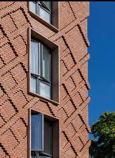 a tall brick building with two windows on each side and one window in the middle