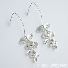 A beautiful pair of linear dangle earrings with rhodium-plated (white gold) V-shaped earwires suitable for sensitive skin.  Attractive shiny silver-plated triple tier orchid flowers.  Comes gift wrapped ready for gift giving.♥ Rhodium-plated (white gold) V-shaped linear earrings (approx. 35mm length)♥ Silver-plated triple orchid dangling charms (approx. 35mm)♥ Always gift wrapped ♥[ Matching necklace also available separately ]______________________________________________________________Follow Silver Flower Shaped Hoop Earrings For Wedding, Delicate Silver Flower Earrings, Delicate Silver Drop Flower Earrings, Delicate Sterling Silver Linear Earrings, Minimalist Sterling Silver Flower Earrings For Wedding, Delicate Silver Linear Earrings For Formal Occasions, Elegant Silver Linear Earrings With French Hook, Hypoallergenic Sterling Silver Flower Earrings For Wedding, Elegant Flower-shaped Earrings With French Hook