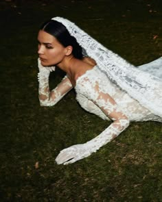 a woman laying on the ground wearing white lace