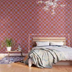 a bedroom with a bed, rug and chandelier in front of a checkered wall