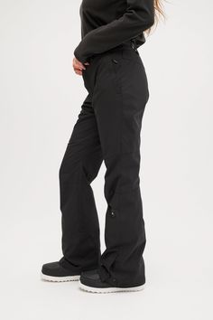 a woman in black pants standing with her hands on her hips