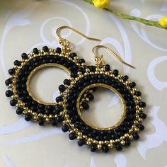 Stunningly beautiful seed bead hoop earrings made with black 8/0 and gold metallic 11.0 seed beads. The french hook earwires and findings are are 14kt gold plated. These very lightweight earrings are handmade by me with each tiny bead individually woven. They measure 2 inches total including the earwires. The hoops are 1.5 inches. These earrings go perfectly with all outfits and occasions. Wear these stunning earrings and get ready for compliments Thanks for looking and please stop by again. Black Beaded Small Hoop Earrings As Gift, Small Black Hoop Earrings For Jewelry Making, Gold Round Beaded Earrings With Spacer Beads, Handmade Black Beaded Small Hoop Earrings, Black Beaded Hoop Earrings Gift, Black Beaded Round Hoop Earrings, Adjustable Gold Beaded Earrings With Black Beads, Black Earrings With Tiny Round Beads, Seed Bead Hoop Earrings