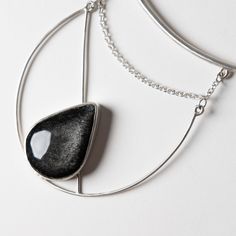 This one of a kind statement piece is hand fabricated in sterling silver, with a beautiful silver sheen obsidian. Collar size is slightly adjustable. Handcrafted in San Francisco. In stock and ready to ship. Silver Obsidian Necklaces, Silver Obsidian Pendant Necklace, Silver Obsidian Gemstone Necklace, Silver Obsidian Necklace With Natural Stones, Silver Onyx Necklace With Polished Finish, Modern Adjustable Jewelry With Large Stone, Modern Silver Jewelry With Large Stone, Modern Onyx Pendant Jewelry, Silver Agate Teardrop Pendant Jewelry