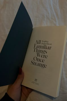 a person is holding an open book in their hand with the title all about familiar things we're once strange