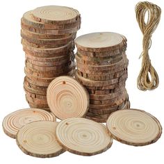 a stack of wooden discs next to a rope and some wood slices on the ground