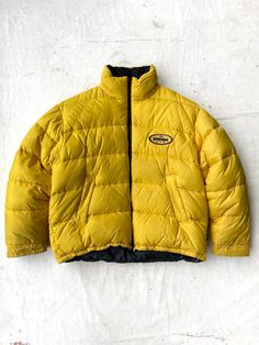 Great condition. * Hideaway hood. * Big & boxy. * Materials: Nylon shell, Down filling. * Size: Tagged X-Large, fits up to XXL.   Measurements: Chest: 27 inches. Length: 26 inches. Oversized Nylon Puffer Jacket For Streetwear, Urban Oversized Nylon Puffer Jacket, Urban Oversized Puffer Jacket For Outdoor, Yellow Windbreaker With Detachable Hood For Winter, Yellow Nylon Outerwear For Streetwear, Urban Style Outdoor Puffer Windbreaker, Oversized Outdoor Puffer Hooded Jacket, Oversized Puffer Hooded Jacket For Outdoor, Yellow Outerwear With Adjustable Hood For Streetwear