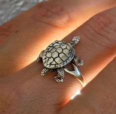 Paws, head and tail move - mobile :) A turtle ring silver with moving elements is a type of ring that features a turtle design with movable parts, often made of silver. The turtle is a beloved symbol of longevity, wisdom, and protection, and is often depicted in art, clothing, and jewelry. Overall, a turtle ring silver with moving elements can make a fun and playful addition to your jewelry collection, and is a great way to show your love and appreciation for turtles and their symbolic meanings. Dussehra Wishes, Freemason Ring, Symbolic Meanings, Turtle Ring, Frog Pins, Happy Dussehra, Silver Flower Ring, Animal Ring, Signet Ring Men