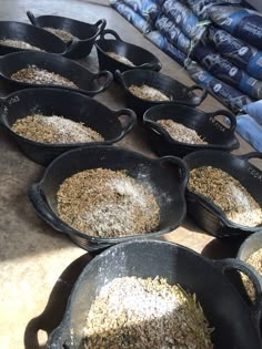 several black pans filled with food sitting on top of a table