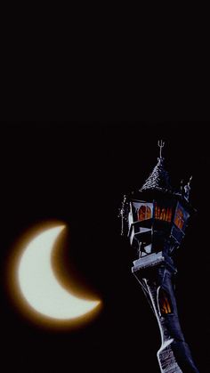 the moon is seen behind a clock tower