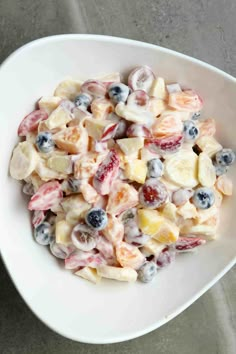 a white bowl filled with fruit salad on top of a table