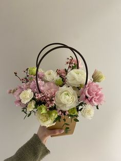 a person holding a basket with flowers in it