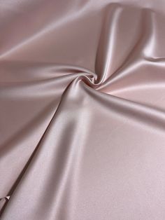 100% Polyester  58 to 60 Inches Wide Medium Weight This fabric is an exquisite medium-weight satin with a beautiful blush color and a subtle, luxurious sheen. Its lack of stretch is complemented by its gorgeous drape, making it an ideal choice for crafting a range of items--from party gowns to elegant skirts, dresses, evening gowns, pants, and even drapes and home décor. Multiple yardages will come in one piece. *Due to the lighting when taking the photos and differences in screen resolutions & settings, the color shade(s) of the fabric might not be exactly as shown when you receive it. Satin Fabric By The Yard, Pink Silk Satin Wedding Dress, Pink Elegant Silk Satin Dress, Elegant Pink Silk Satin Dress, Feminine Formal Satin Dress, Feminine Pink Satin Dress For Wedding, Feminine Pink Satin Dress For Formal Occasions, Pink Satin Dress For Formal Occasions, Satin Fabric Texture