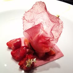 a white plate topped with sliced strawberries on top of a red cloth covered in ice