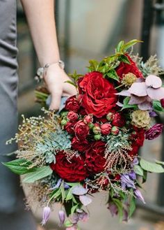 a woman holding a bouquet of flowers in her hand