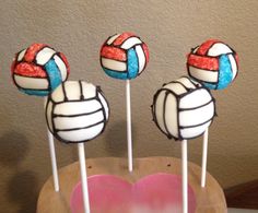 three lollipops with volleyball balls sitting on top of each other in front of a heart